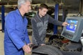 apprentice mechanic and teacher retreading wheel in automotive workshop Royalty Free Stock Photo