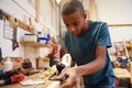 Apprentice Planing Wood In Carpentry Workshop Royalty Free Stock Photo