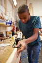 Apprentice Planing Wood In Carpentry Workshop