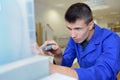 Apprentice with spanner working on machine part Royalty Free Stock Photo