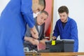 Apprentices learning to fit door mechanism Royalty Free Stock Photo