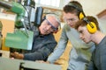 Apprentices learning to use industrial machine Royalty Free Stock Photo