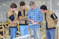 Apprentices reading plans held by instructor