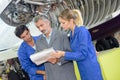 Apprentices and teacher fixing aiplane