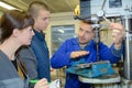 Apprentices working on machine - metal processing