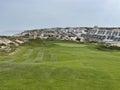 Approach shot by the ocean with sandy beach from the tee with flag by the sea in Portugal Royalty Free Stock Photo