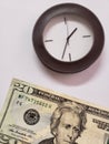 approach to American banknote of twenty dollars and background with a circular wall clock Royalty Free Stock Photo