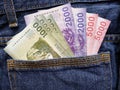 approach to back pocket of jeans in blue with chilean banknotes