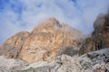 Approach to Cesare Piazzetta via ferrata start, with impressive Dolomites rock walls lit by sunlight, rock scree at the bottom