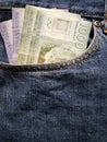 approach to front pocket of jeans in blue with chilean banknotes