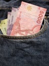 approach to front pocket of jeans in blue with chilean banknotes