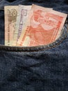 approach to front pocket of jeans in blue with honduran banknotes