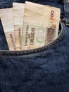 approach to front pocket of jeans in blue with uruguayan banknotes