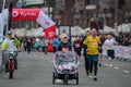 Approaching the finish line of the race winner with a sidecar. Mom-athlete lucky twins girls in a stroller