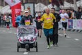 Approaching the finish line of the race winner with a sidecar. Mom-athlete lucky twins girls in a stroller