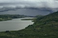 Approaching storm front in the highlands. A view of the green hills and the lake. Royalty Free Stock Photo