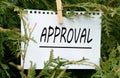 APPROVAL - word on white paper with clothespin on a green background of branches