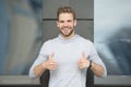 Approve or recommend concept. Man with brilliant smile unshaven face shows thumbs up gesture urban background. Guy happy Royalty Free Stock Photo