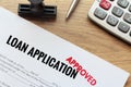 Approved loan application with rubber stamp and calculator