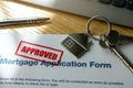 approved mortgage loan application form and new house keys on the table