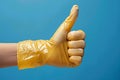 Approving sign Hand in rubber glove offers thumbs up gesture