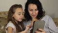 Approximation, zoom, daughter teaches mother to play the game on the tablet.