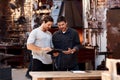 These apps help us run our workshop better. two handsome young using a digital tablet while working together inside Royalty Free Stock Photo