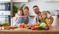 Appy family with child preparing vegetable salad