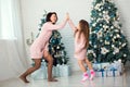 Appy family mother and child daughter on Christmas morning at the Christmas tree with gifts