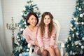 Appy family mother and child daughter on Christmas morning at the Christmas tree with gifts