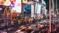 Apr 4, 2019: Crowd of people walking, car and taxi traffic transportation, and advertisement at night in Times Square Royalty Free Stock Photo