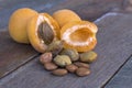 Apricot fruit cut open with pips and kernels in the foreground.