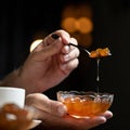 Apricot jam, Fruit or berry confiture. Male hands hold spoon and glass bowl of jam on black background. Soft focus. Copy