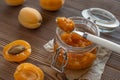 Apricot jam in a glass jar with a spoon and ripe apricots on a wooden table Royalty Free Stock Photo