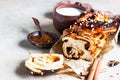 Apricot jam twisted loaf bread or babka with nuts and spices on concrete background with a cup of milk. Homemade yeast bun babka Royalty Free Stock Photo