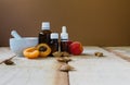 Apricot kernel cosmetic oil in dark glass bottles and a porcelain mortar on a light wooden table. Natural oils Royalty Free Stock Photo