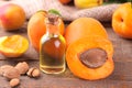Apricot seed oil next to apricots on a brown background Royalty Free Stock Photo