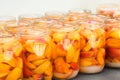 Apricot slices with water and sugar in jars. Homemade fruit compotes ready to be lidded and sterilised. Preparing winter supplies Royalty Free Stock Photo