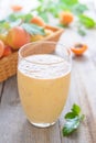 Apricot smoothie and a basket of apricots on background