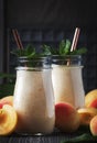 Apricot smoothies with fruits and flax seeds in glass bottles, dark rustic kitchen table background, place for text, selective