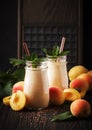 Apricot smoothies with fruits and flax seeds in glass bottles, dark rustic kitchen table background, place for text, selective