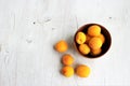 Apricots in a clay bowl on a white wooden background. Still life in a rustic style. Royalty Free Stock Photo