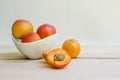 Apricots in white bowl with open apricot