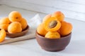 apricots in a wooden bowl on a light wooden background, apricot cut in half Royalty Free Stock Photo