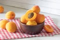 apricots in a wooden bowl on a red checkered towel, apricot cut in half Royalty Free Stock Photo