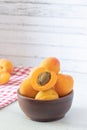 apricots in a wooden bowl on a white wooden background, apricot cut in half Royalty Free Stock Photo