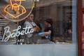 April 2019,Babett cafe, Moscow, Russia. Photo taken through the cafe window.The girl in the blue hat and the glove that says the