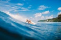 April 04, 2021. Bali, Indonesia. Sporty young woman in tropical ocean during surfing. Surfer girl on surfboard and perfect wave