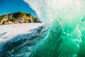 April 18, 2019. Bali, Indonesia. Surfer ride on barrel wave. Professional surfing at big waves in Padang Padang Royalty Free Stock Photo