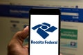 Logo of the Receita Federal do Brasil in the mobile device. Concept of income tax, economy, interest, taxes